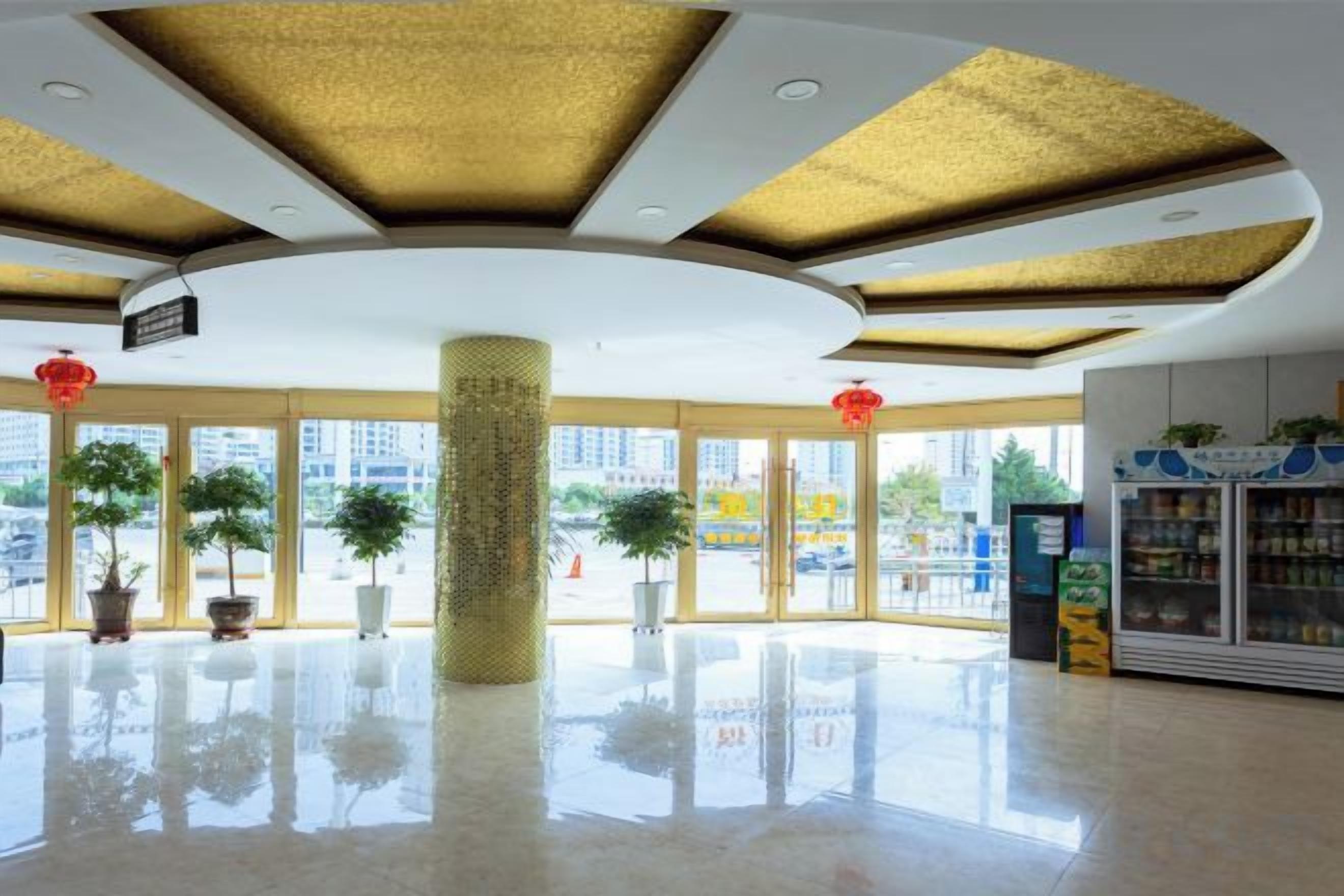 A spacious lobby with a high ceiling, large windows, and a central pillar.
