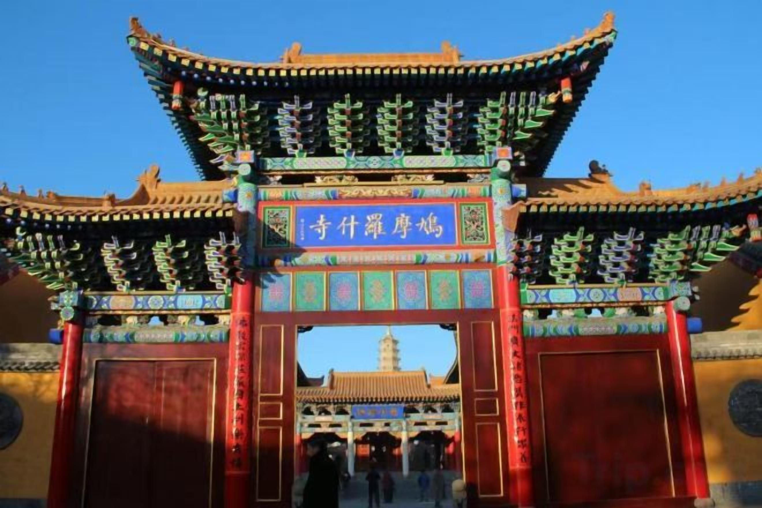 A traditional Chinese gate with intricate designs and a clear blue sky in the background.