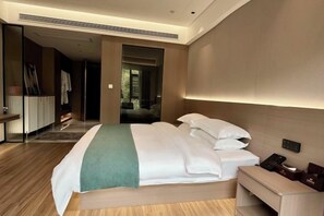 Une chambre d’hôtel moderne avec un grand lit, une table de chevet et un miroir.