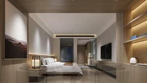 Ein modernes Hotelzimmer mit einem großen Bett, Nachttischen, einem Flachbildfernseher und einer Holzregalanlage.