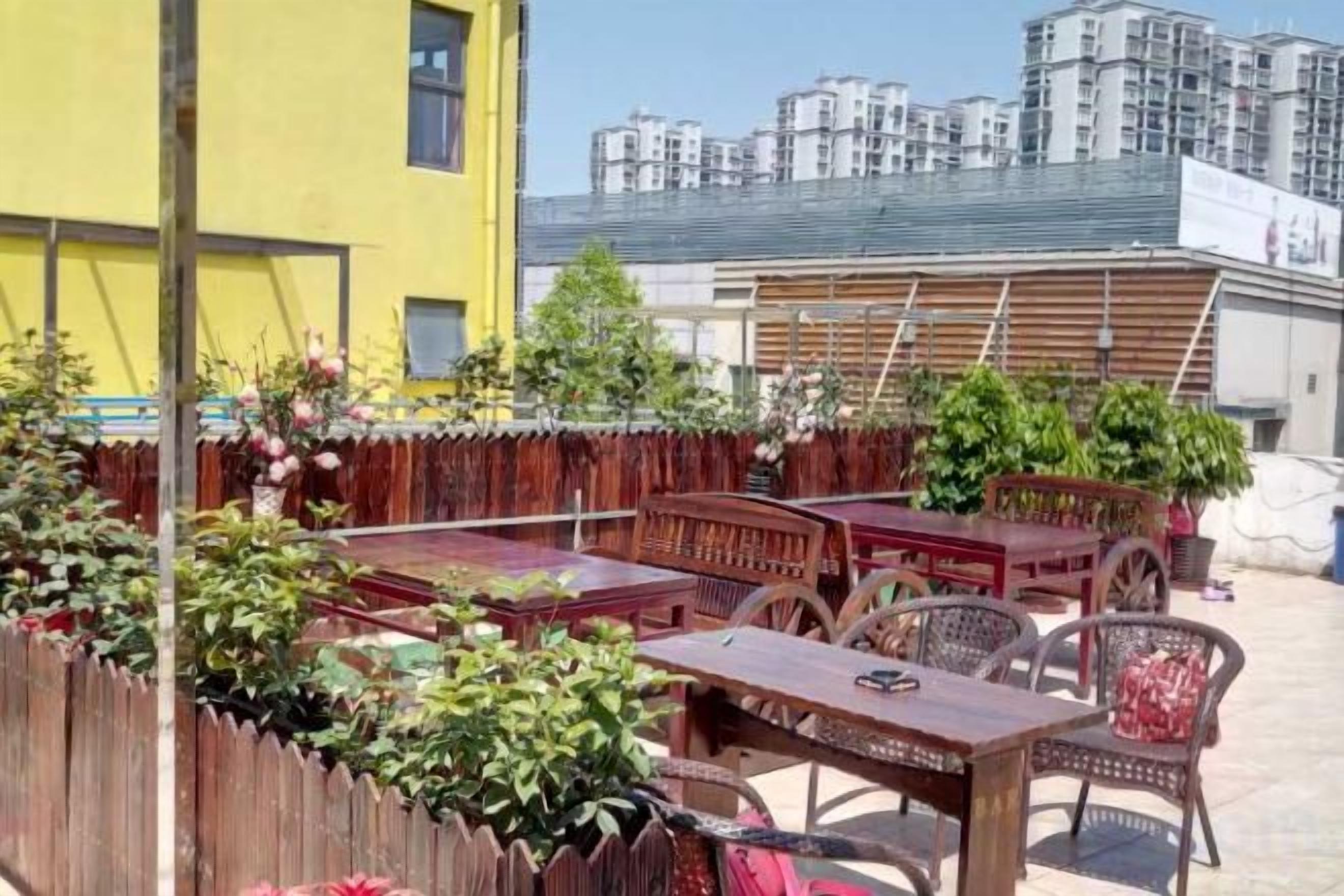 An outdoor seating area with wooden furniture and potted plants.
