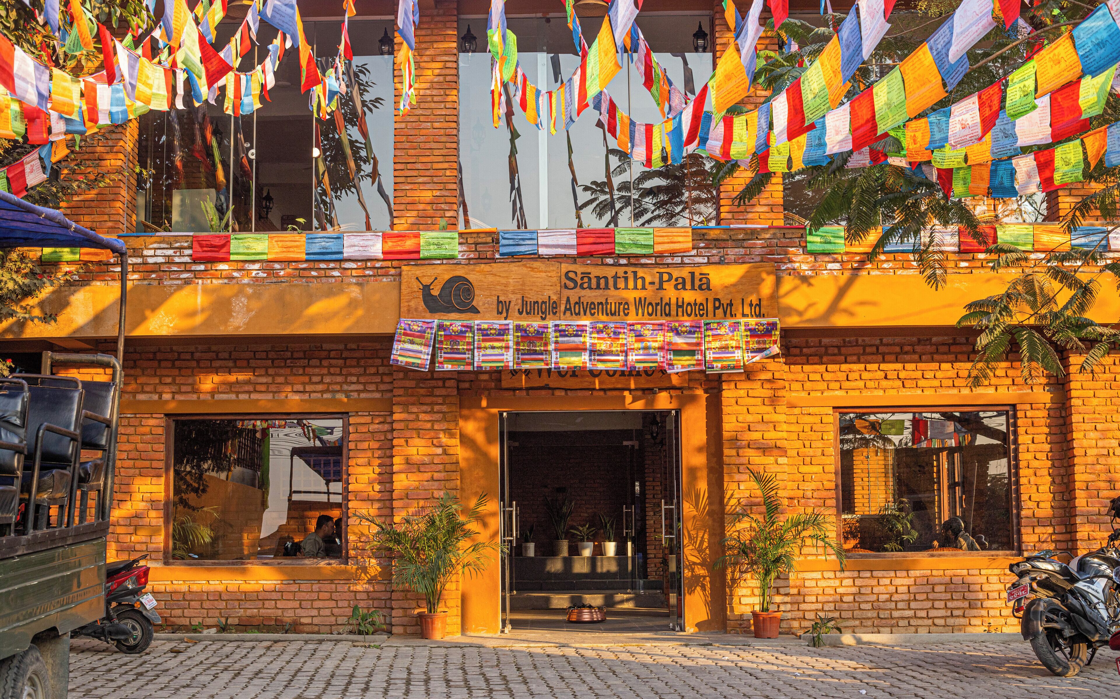 A building with a sign reading "Santih-Palace by Jungle Adventure World Hotel Pvt. Ltd."