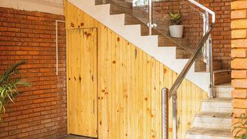 Una escalera con un muro de madera y baranda de cristal.
