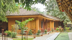 A traditional building with a tiled roof, a covered walkway, and a small water feature. - Jungle Adventure World Hotel Pvt. Ltd (Sauraha)