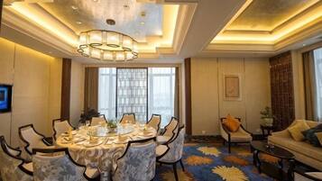 A dining area with a round table, chairs, and a chandelier.