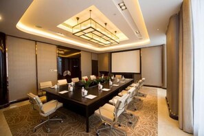 A conference room with a long table, chairs, a projector screen, and a modern chandelier. - KinDream Hotel (Yongkang)