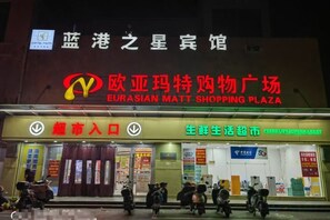 Un centro comercial con un letrero llamativo que indica Eurasian Matt Shopping Plaza.