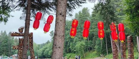 A parking area with trees and red lanterns.