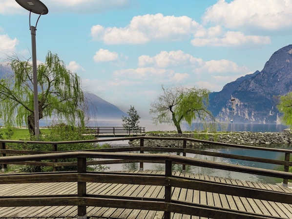 A wooden bridge over a calm lake with a mountain in the background.