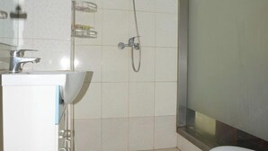A bathroom with a shower, a sink, and a mirror. - Longyuan Express Hotel (Shanghai)