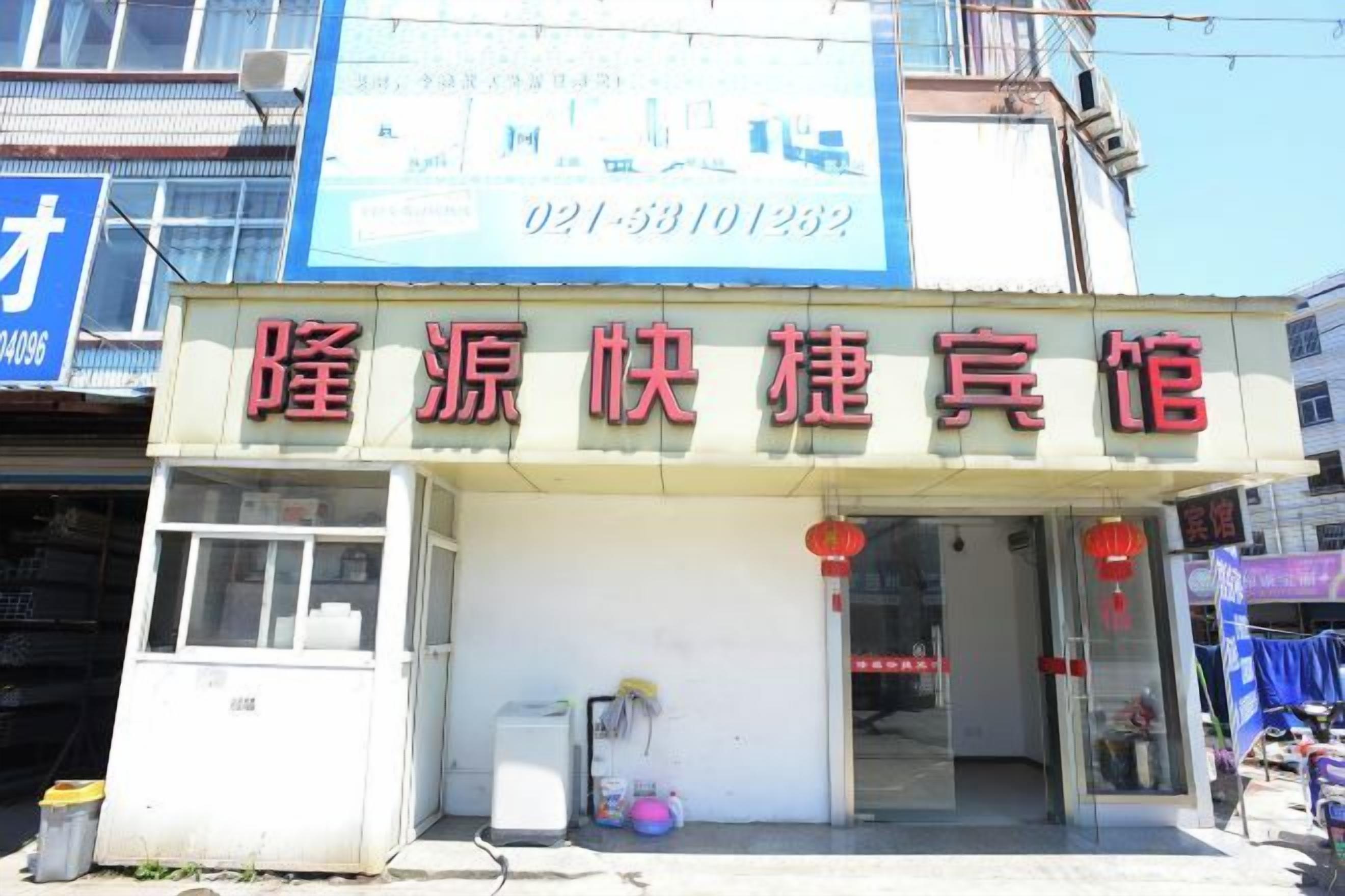 A building with a sign in Chinese characters, a visible entrance, and a small window on the ground floor.