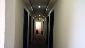 A narrow hallway with doors on both sides, leading to a room at the end. - Longyuan Express Hotel (Shanghai)