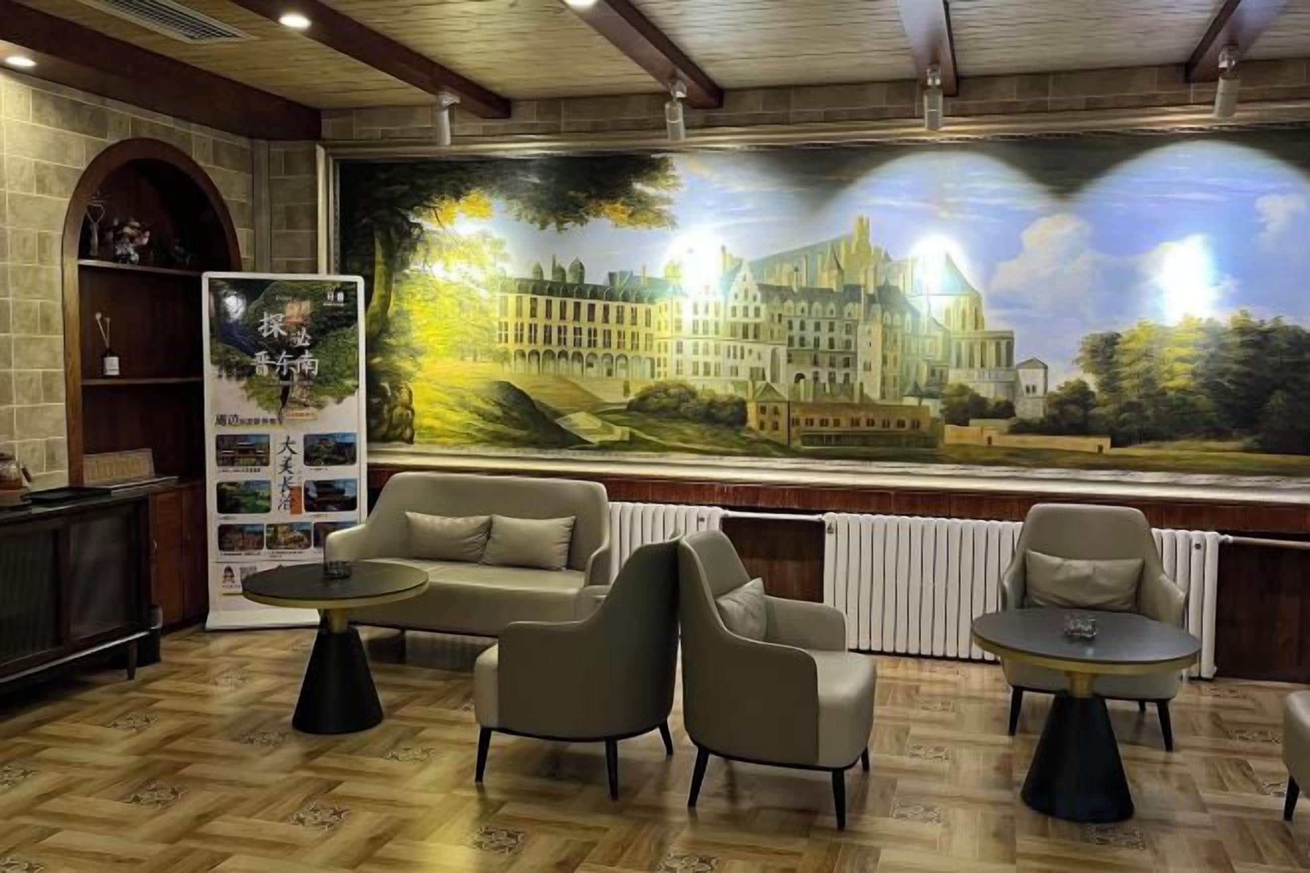 A lobby with a large mural, seating area, and a fireplace.