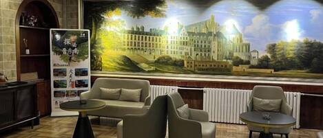Um saguão com um grande mural, área de estar e lareira.