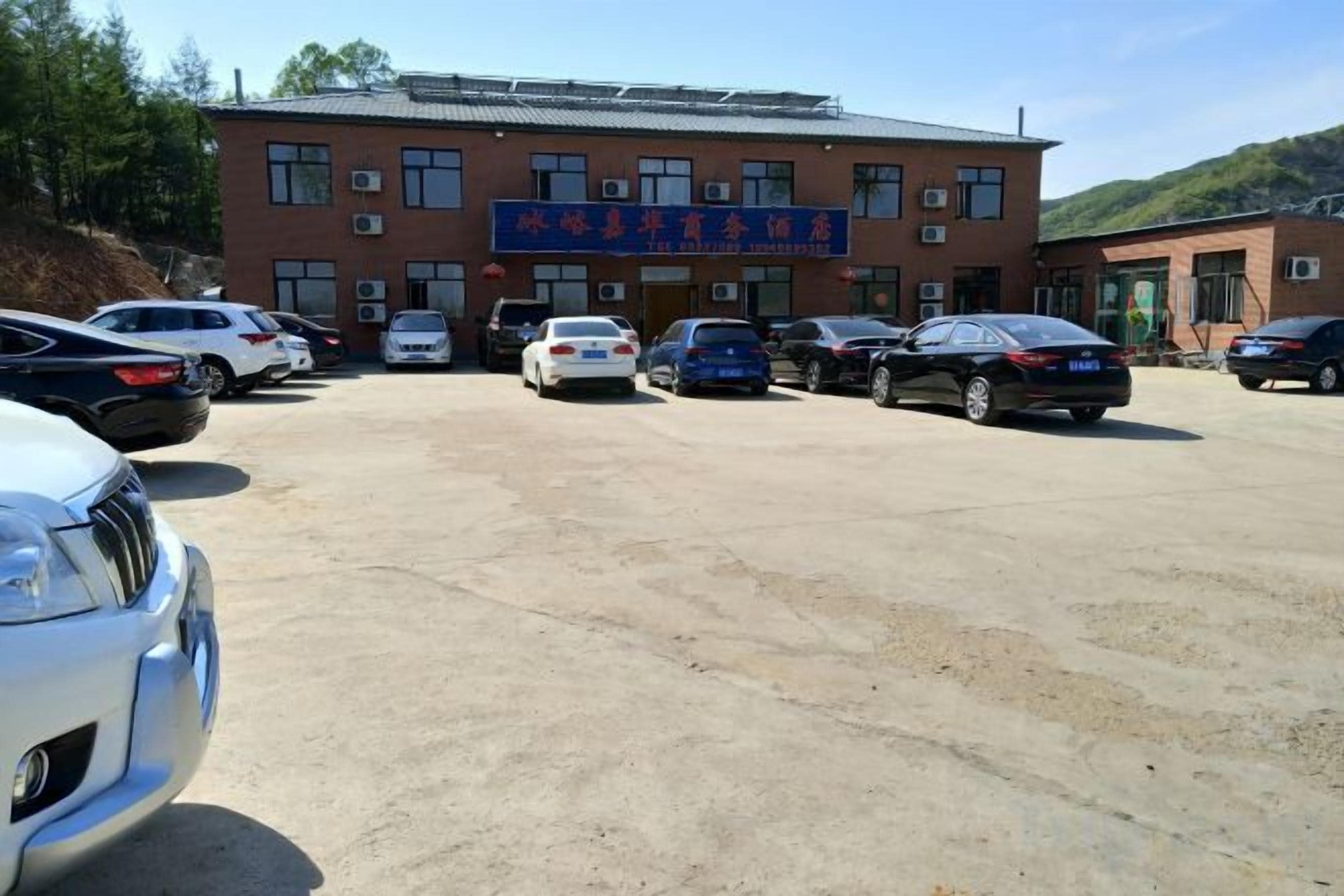 A parking lot with multiple cars and a building with a sign.