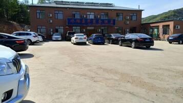 A parking lot with multiple cars and a building with a sign.