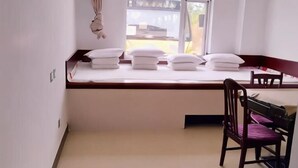 A room with a bed, a chair, a window, and a view of the outside. - Bingyugou Jiahua Business Hotel (Zhuanghe)