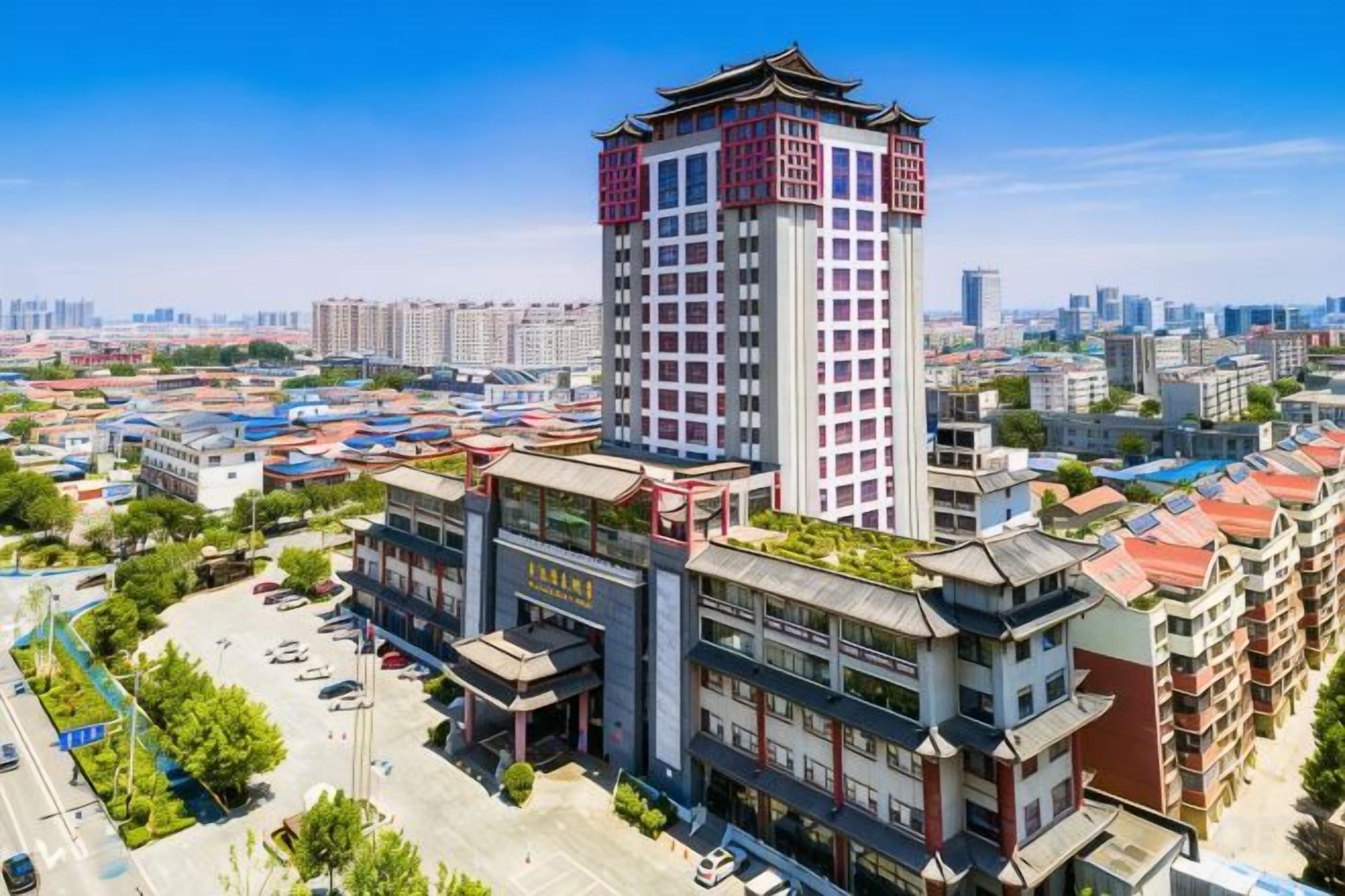 A high-rise building with a traditional architectural style, surrounded by other residential buildings and a clear sky.
