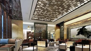 A modern lobby with seating areas, a large artwork on the wall, and a decorative ceiling. - Qingtengyuan Hotel (Binzhou)