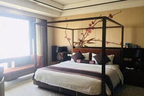 A four-poster bed with a canopy, a nightstand with a lamp, and a large window with curtains. - Qingtengyuan Hotel (Binzhou)
