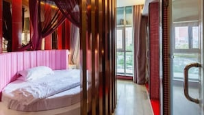 Ein Schlafzimmer mit Bett, Vorhängen und Blick ins Freie.