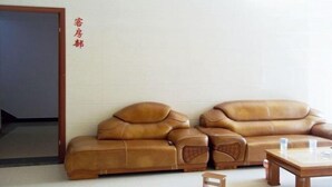 A room with two brown leather sofas and a wooden coffee table. - Sanzao Hostel (Shanghai)
