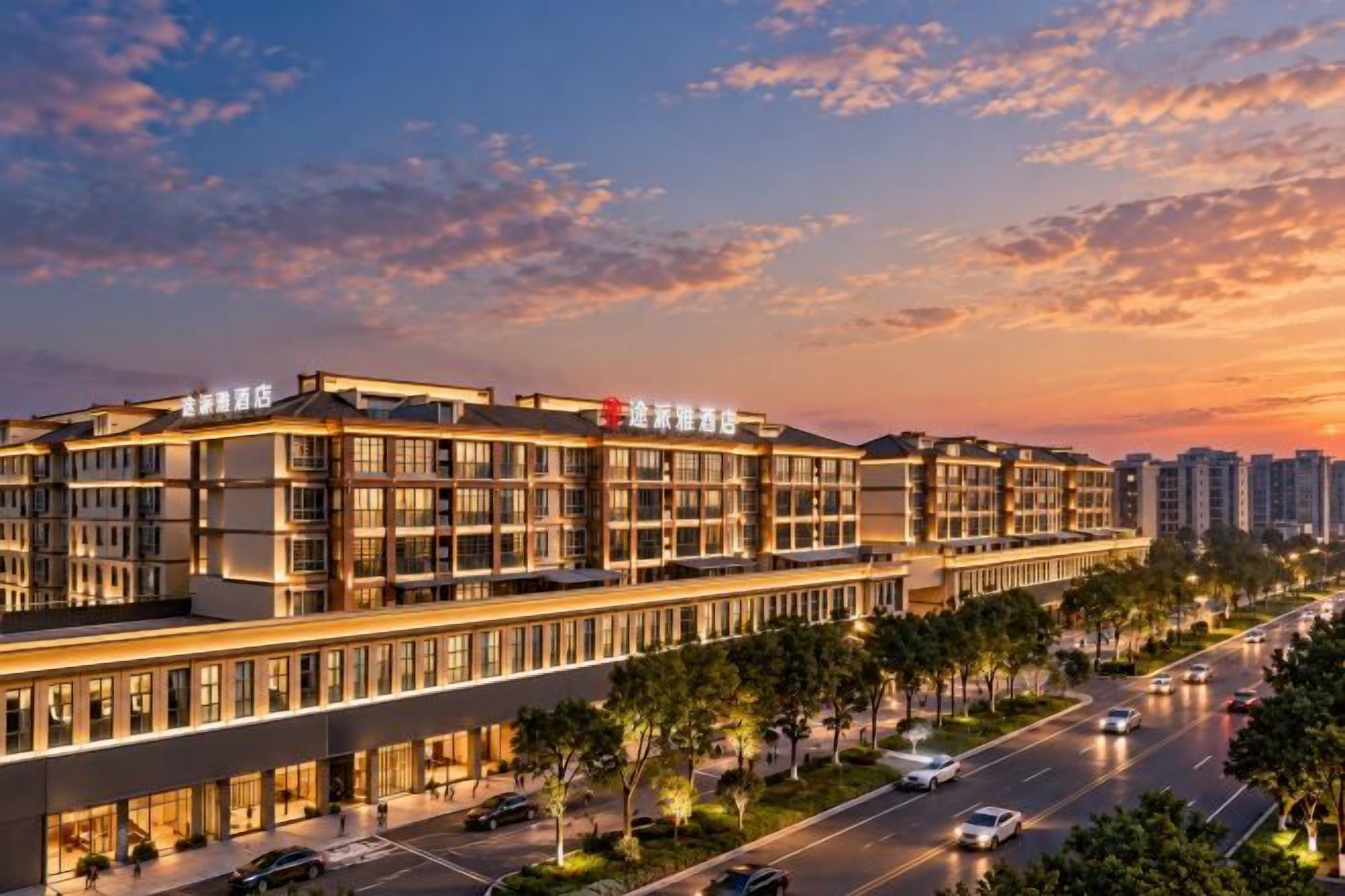 A multi-story hotel with a modern architectural design, featuring a prominent entrance and a series of balconies.