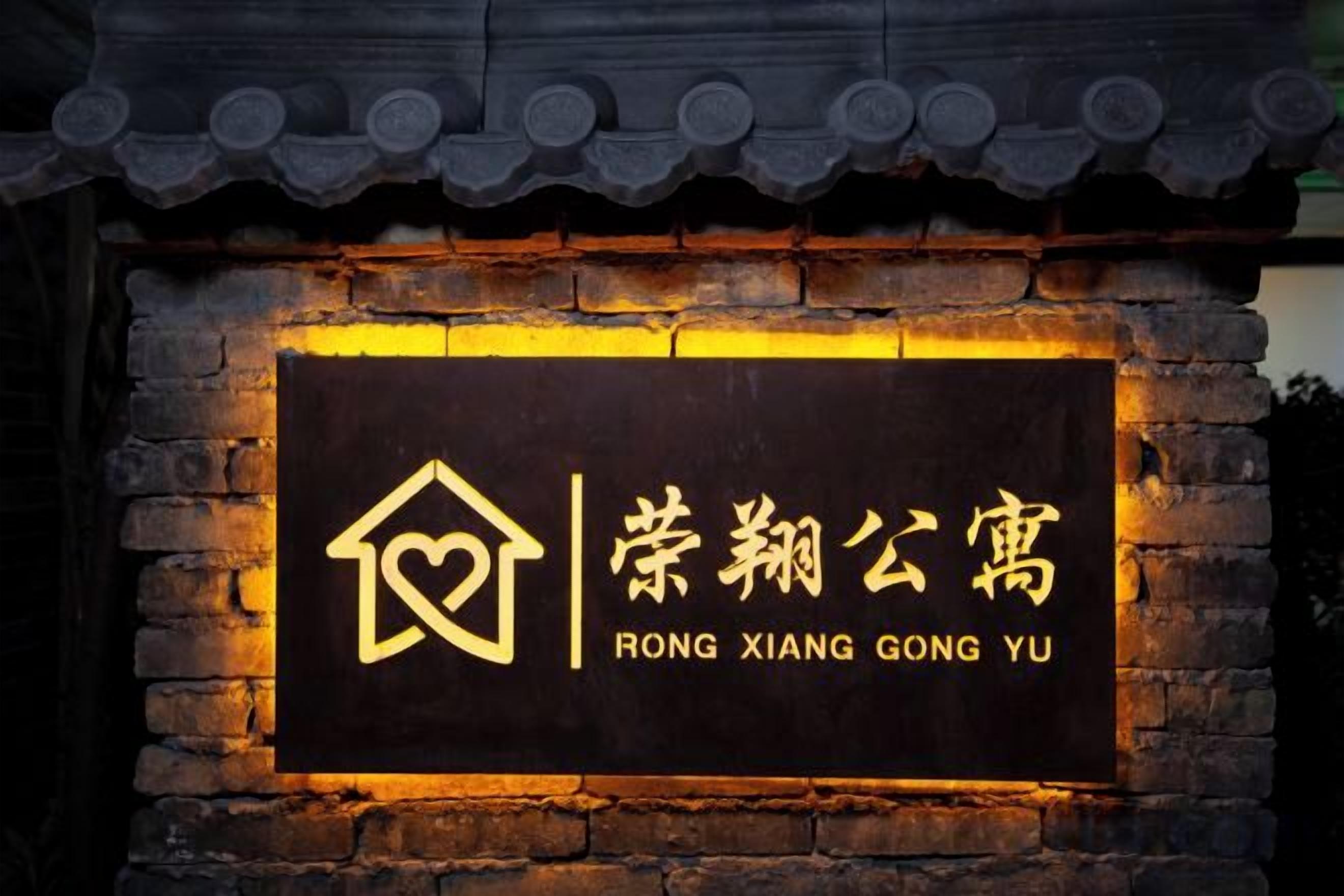 A sign with a house icon and Chinese characters, indicating a hotel named 'RONG XIANG GONG YU'.