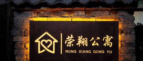A sign with a house icon and Chinese characters, indicating a hotel named 'RONG XIANG GONG YU'.