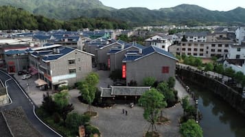 Il s’agit d’un bâtiment traditionnel doté d’une cour intérieure, entouré d’autres constructions et situé à proximité d’un plan d’eau.