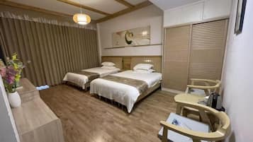 A hotel room with two beds, a desk, and a chair.