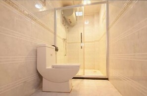 Un baño moderno con ducha de vidrio, inodoro blanco y paredes con azulejos.