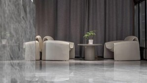 Una habitación moderna con dos sofás, una mesita redonda y una planta en maceta.