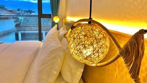 A room with a bed, a hanging lamp, and a view of a cityscape. - ayan house (Dali City)