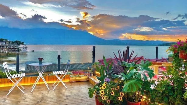 A deck with outdoor seating, overlooking a body of water and mountains. - ayan house (Dali City)