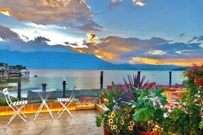 A deck with outdoor seating, overlooking a body of water and mountains. - ayan house (Dali City)