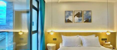 A modern hotel room with a large bed, a view through a glass wall, and a wooden ceiling.