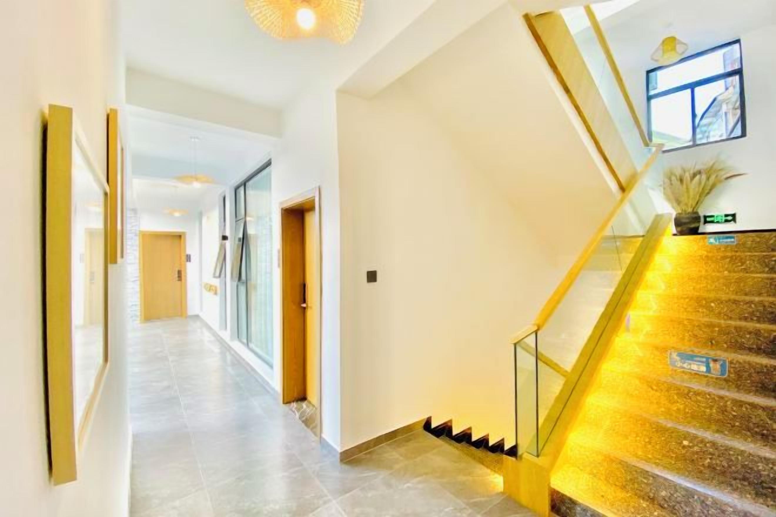 Un interior moderno con una escalera, un pasillo y una puerta que da a otra habitación.