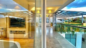 A modern hotel lobby with a glass partition, a seating area, and a view of a rooftop garden. - ayan house (Dali City)