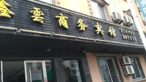 A hotel sign with Chinese characters and the name "Xinyun Hotels" in English. - XINYUN BUSINESS HOTEL (Zhoushan)