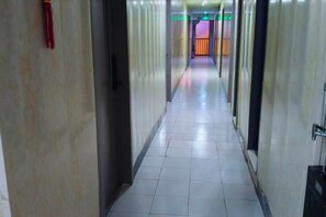 Passadís llarg i estret d'un hotel, amb portes a banda i banda, que condueix a les habitacions.