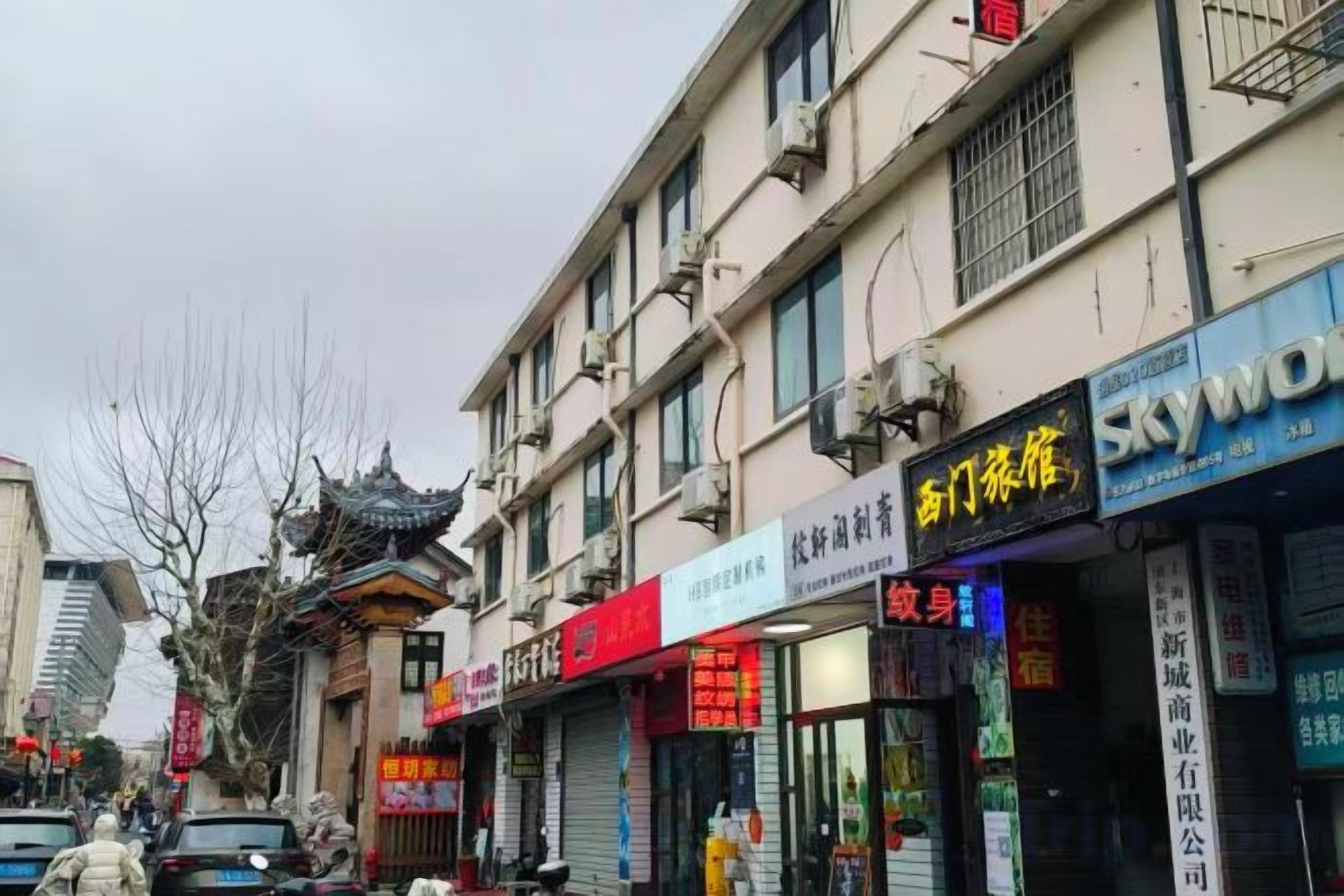 A street with multiple storefronts, including a pharmacy and a hotel.