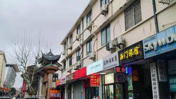 A street with multiple storefronts, including a pharmacy and a hotel.