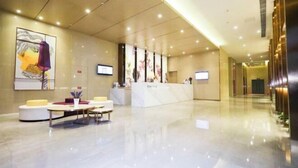 Eine geräumige Lobby mit Empfangstresen, Sitzgelegenheiten und Kunstwerken an den Wänden.