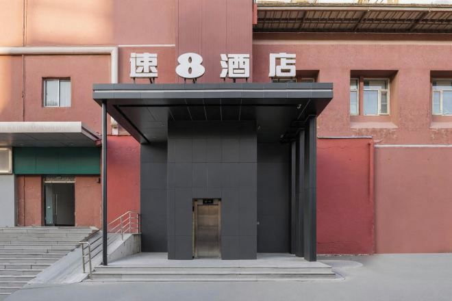 Entrada de un hotel con un letrero que dice "速8酒店" (Speed 8 Hotel).