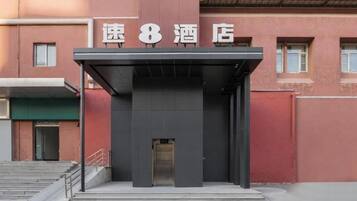 Entrada de un hotel con un letrero que dice "速8酒店" (Speed 8 Hotel).