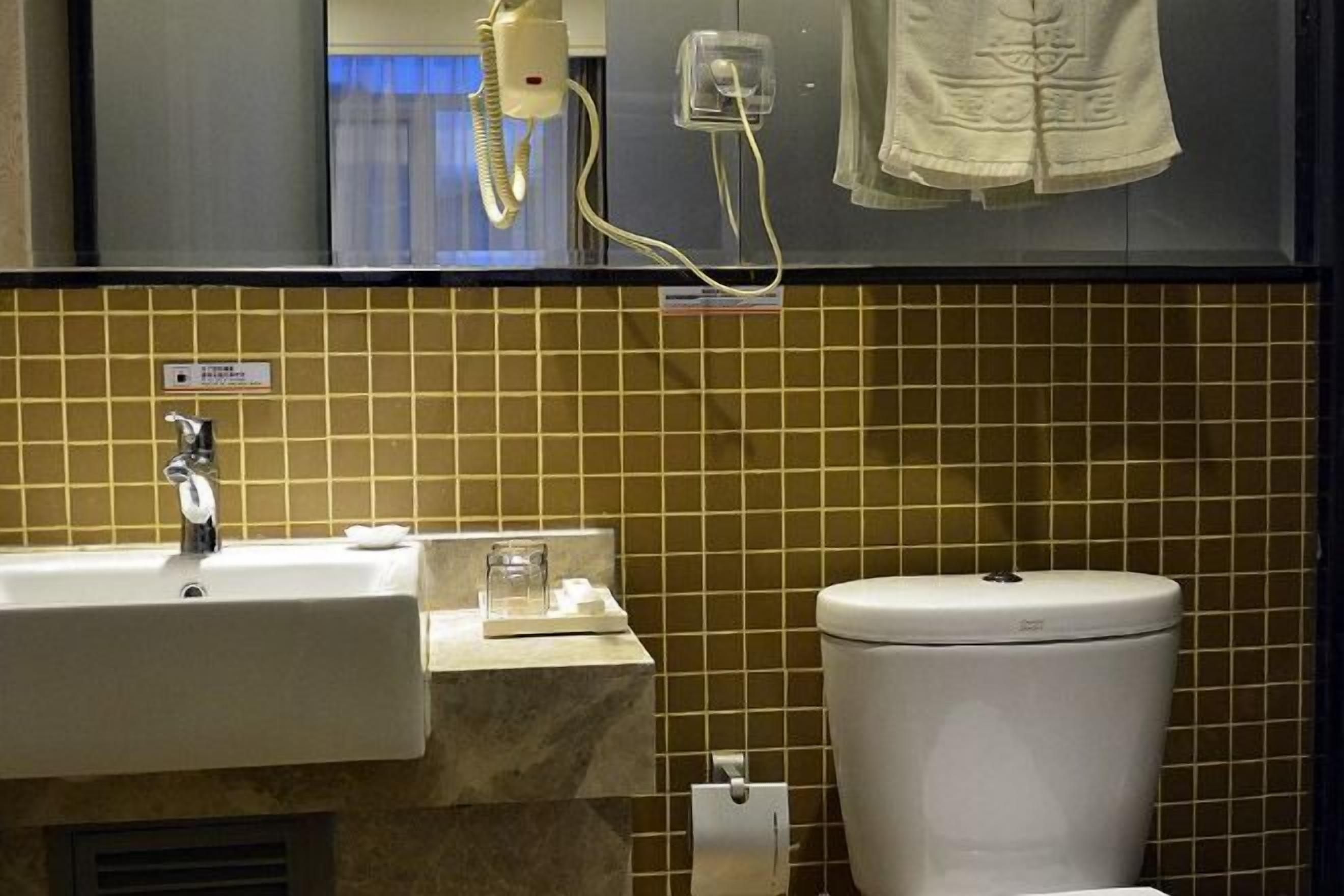 A bathroom with a sink, toilet, and a mirror.