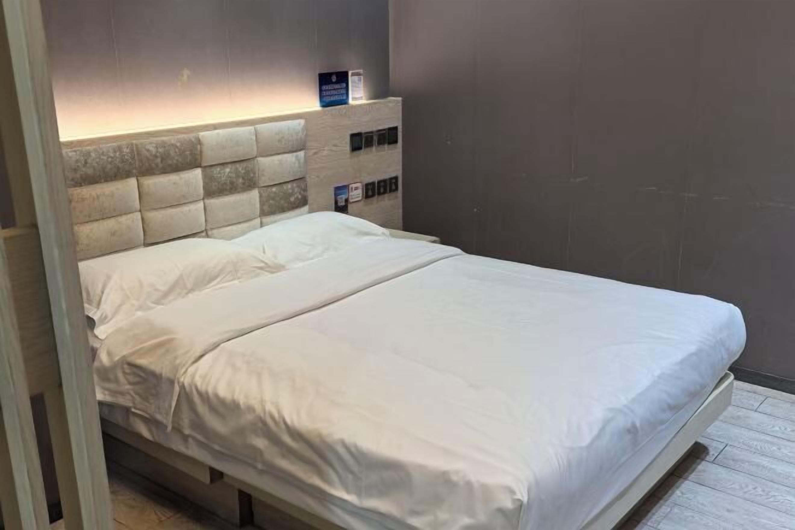 Ein ordentlich bezogenes Bett mit weißen Leinen in einem Hotelzimmer.