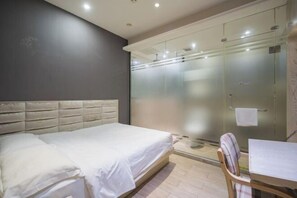 A bedroom with a bed, a chair, and a table. There is a glass shower enclosure and a towel hanging on the wall. - Super 8 Hotel (Beijing Huayuanqiao Subway Station Capital Normal University) (Beijing)