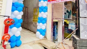 A hotel entrance with a blue and white balloon archway and a signboard. - Hotel ornate  (Chandauli)